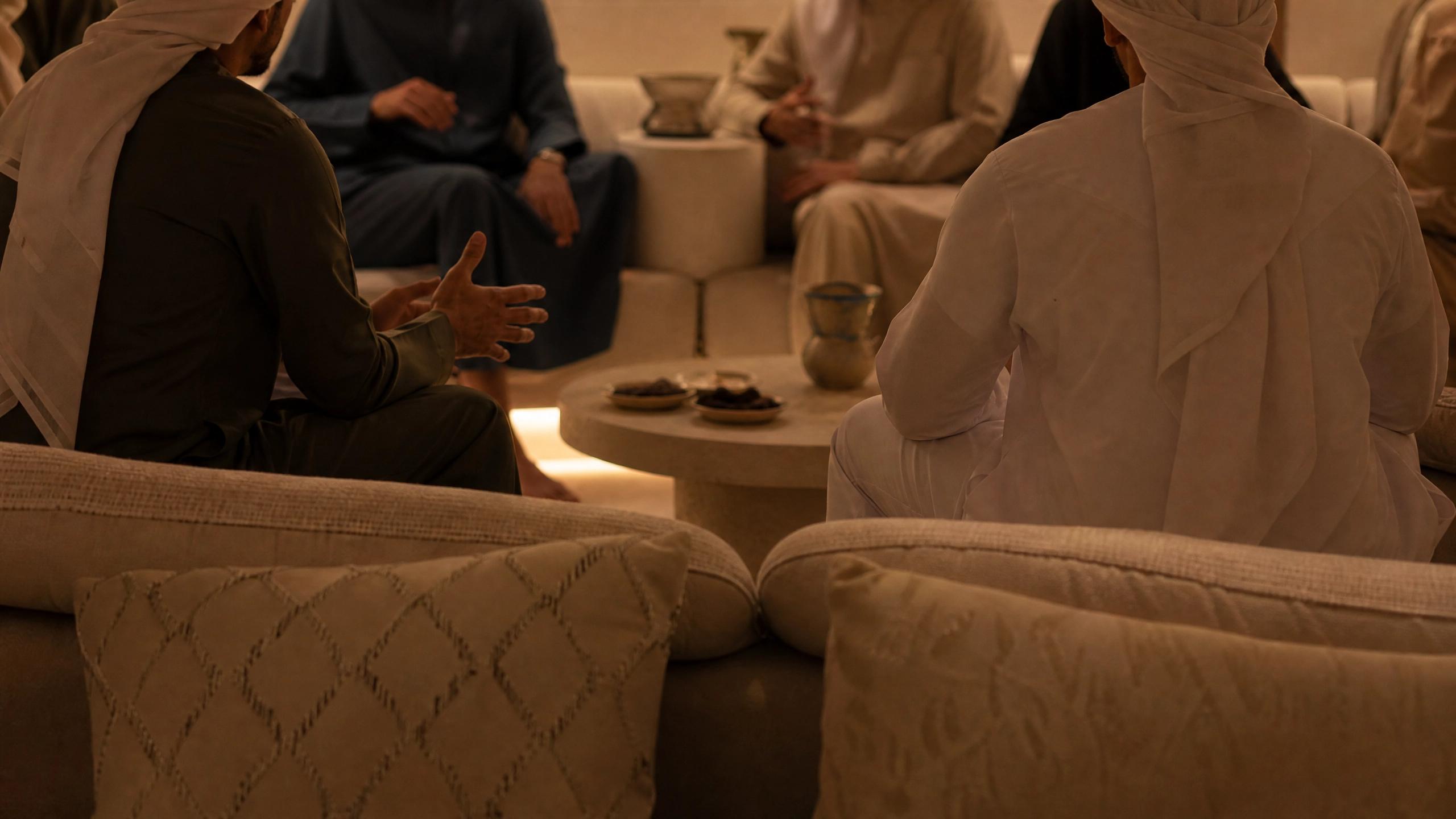 A warm gathering of family and friends sitting together in a circle during Islamic New Year, illustrating the concept of presence as a meaningful gift.